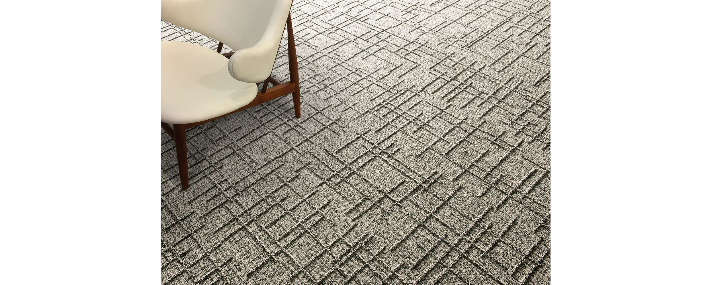 Detail of Interface DL925 carpet tile with cream colored chair imagen número 2